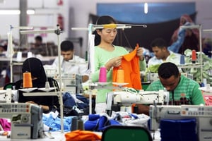 Des contremaîtres chinois interviennent à l’usine Nile Textile Group située dans la zone franche de Port-Saïd, en Égypte. © KHALED DESOUKI/AFP