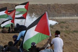 Les manifestants palestiniens se mettent à l’abri devant des gaz lacrymogènes tirés par des troupes israéliennes près de la clôture de la frontière entre Gaza et la bande de Gaza, lors d’une manifestation à l’est de la ville, le 16 novembre 2018. © Adel Hana/AP/SIPA