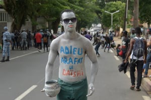 Un fan de DJ Arafat le corps peint en blanc, le 30 août 2019 à Abidjan non loin du stade Houphouët-Boigny, lors des funérailles de l’artiste. © OLIVIER pour Jeune Afrique