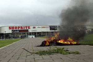 Feu de pneus allumé à Abuja, le 4 septembre 2019 devant une enseigne de la chaîne sud africaine Shoprite, lors de violences en représailles de celles qui ont visées des commerces étrangers la même semaine, en Afrique du Sud. © AP/SIPA