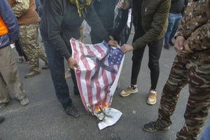 Lors des funérailles du général Qassem Soleimani, un drapeau américain brûle, le 4 janvier 2020 à Baghdad, en Irak. © Nasser Nasser/AP/Sipa