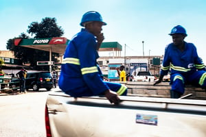 Construction workers ride in the back of a pickup truck past a Puma Energy Holdings Pte. Ltd. gas station Lilongwe, Malawi, on Tuesday, June 26 2018. The diversification of the agriculture-reliant economy is a top priority, Malawian President Peter Mutharika said in an interview on Monday. Photographer: Waldo Swiegers/Bloomberg via Getty Images…. © W.Swiegers/Bloomberg via Getty Images