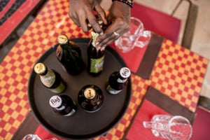 Une serveuse présente les bouteilles de bière des marques Castel, au Sénégal. Image d’illustration. © Sylvain Cherkaoui pour Jeune Afrique
