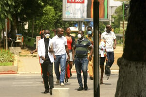 Des passants munis de masques, à Abidjan le 19 mars 2020. © Diomande Ble Blonde/AP/SIPA