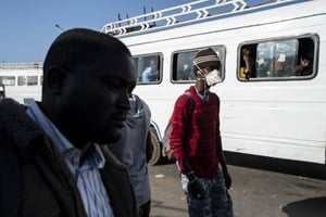Au Sénégal, des voyageurs se protègent de l’épidémie de coronavirus, à Dakar, le 24 mars 2020. © Sylvain Cherkaoui/AP/SIPA