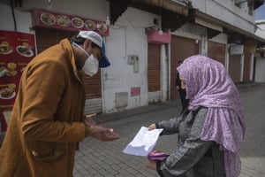 Un membre des forces de sécurité vérifient le permis de sortie d’une Marocaine, à Rabat, le 22 mars 2020. © Mosa’ab Elshamy/AP/SIPA