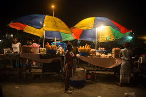 Des femmes proposent des repas chauds sur des étals de rues typiques, la nuit sur le boulevard du 24 novembre à Kinshasa, en 2014. (Archives / illustration) © Gwenn Dubourthoumieu / Jeune Afrique