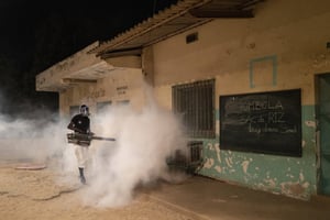 Un employé municipal diffuse du désinfectant dans une école de Dakar pour inverser la courbe de contagion du Covid-19, le 1er avril 2020. © AP Photo/Sylvain Cherkaoui