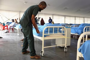 Un technicien mesure la distance entre les lits dans un centre d’isolement des malades du Covid-19, à Kano, Nigeria, le 7 avril. © AMINU ABUBAKAR/AFP