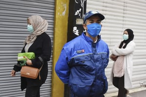Un garde de sécurité se tient à côté de femmes portant des masques, gardant des distances sociales et faisant du shopping pour le ramadan, à Tunis, le 23 avril. © Hassene Dridi/AP/SIPA