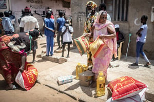 Une femme reçoit des denrées alimentaires, à Dakar, le 28 avril. © Sylvain Cherkaoui/AP/SIPA