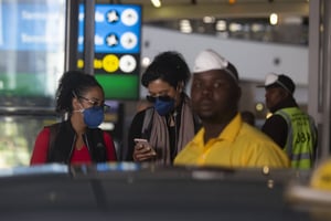 Passagers équipés de masques à l’aéroport de Johannesburg, le 19 mars 2020. © Denis Farrell/AP/SIPA