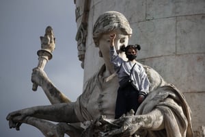 Une manifestante serre le poing alors qu’elle se tient sur une statue de la place de la République lors d’un rassemblement contre le racisme à Paris, le mardi 9 juin 2020. © Francois Mori/AP/SIPA