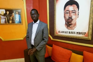 Serigne Mboup, devant le portrait de son père, fondateur du groupe CCBM, à Dakar le 20 février 2020. © Julien Clémençot pour JA