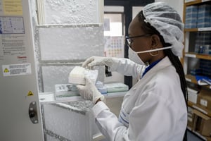 Un technicien de laboratoire prélève des échantillons témoins de Covid-19 dans le congélateur pour faire un test de diagnostic des cas suspects, le 8 avril 2020 a l’Institut de recherche en santé, de surveillance épidémiologique et de formation (IRESSEF) de Dakar. © Sylvain Cherkaoui/SIPA