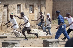 Des Imbonerakure pourchassent des manifestants de l’opposition, sans en être empêchés par les forces de l’ordre, à Bujumbura, le 25 mai 2015 Members of the Imbonerakure pro-government youth militia chase after opposition protesters, unhindered by police, in the Kinama district of the capital Bujumbura, in Burundi Monday, May 25, 2015. Protests continued in the capital Monday, with demonstrators saying they will continue until President Pierre Nkurunziza steps down at the end of his second term. 
© Berthier Mugiraneza/AP/SIPA