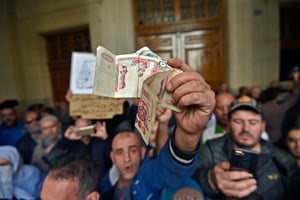 En décembre 2019, au tribunal d’Alger, un homme brandit des billets lors d’ouverture d’un procès pour corruption (illustration). © RYAD KRAMDI /AFP