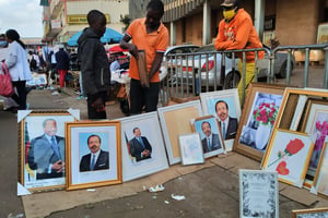 Le Camerounais Agatha Moses (au centre), doyen de la vente des portraits du président Paul Biya, avenue Kennedy, à Yaoundé. © Franck Foute pour JA