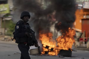 Un policier devant une barricade, à proximité du domicile d’Henri Konan Bédié encerclé par les forces de l’ordre, le 3 novembre 2020. © Leo Correa/AP/SIPA