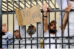 Des partisans des Frères musulmans et d’autres islamistes tiennent une pancarte en carton portant le symbole de la « rabaa », le 19 mai 2014. © Heba Khamis/AP/SIPA
