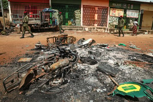 Des soldats marchent à côtés de décombres, à M’Batto, en Côte d’Ivoire, le 12 novembre 2020. © Luc Gnago/REUTERS