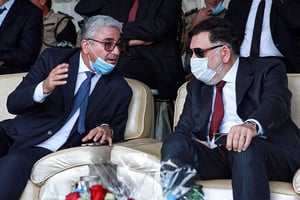 Fayez al-Sarraj (à droite), Premier ministre du gouvernement libyen reconnu par l’ONU, s’entretient avec le ministre de l’Intérieur de ce gouvernement, Fathi Bashagha (à gauche), lors de la commémoration officielle de la « Journée de la police » sur la place des Martyrs à Tripoli, le 8 octobre 2020. © MAHMUD TURKIA/AFP