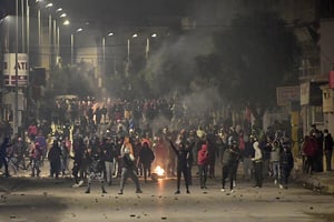 Des manifestants bloquent une rue lors des affrontements avec les forces de sécurité dans la banlieue d’Ettadhamen, dans la banlieue nord-ouest de Tunis, le 18 janvier 2021. © FETHI BELAID/AFP