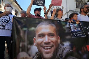 Des Algériens brandissent une banderole à l’effigie du journaliste Khaled Drareni lors d’un rassemblement de protestation contre son emprisonnement dans la capitale Alger, le 14 septembre 2020. © Billal Bensalem/NurPhoto/AFP
