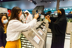 Des visiteurs prennent des photos avec des armes au salon de l’armement d’Abou Dhabi, dimanche 25 février 2021. © Ons Abid
