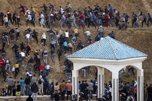 Des migrants évitent la police marocaine alors qu’ils tentent d’atteindre la frontière entre le Maroc et l’enclave espagnole de Ceuta, le 18 mai 2021 à Fnideq. © FADEL SENNA/AFP