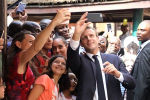 Le président français Emmanuel Macron pose pour des selfies lors d’une visite au lycée français Louis Pasteur le 4 juillet 2018 à Lagos. © Ludovic MARIN / PISCINE / AFP