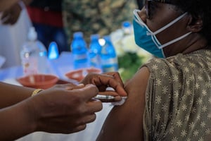 Un médecin ougandais reçoit la première injection du vaccin AstraZeneca à l’hôpital de Mulago à Kampala, le 10 mars 2021. © BADRU KATUMBA/AFP