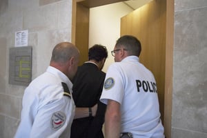 Saad Lamjarred escorté par des policiers au tribunal d’Aix-en-Provence, le 18 septembre 2018. © Boris HORVAT / AFP