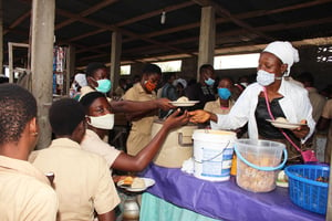 Des élèves portant des masques faciaux font la queue dans le réfectoire d’une école à Cotonou, au Bénin, le 11 mai 2020. © Zounyekpe/Xinhua/Newscom/ABACAPRESS