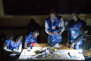 Des agents de la Ceni comptent les votes pendant une coupure d’électricité sous le regard d’observateurs à Lubumbashi, le 30 décembre 2018, après la clôture du vote pour les élections présidentielle, provinciales et nationales. © CAROLINE THIRION/AFP