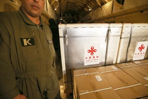 Des membres du personnel déchargent un lot de vaccins chinois contre le Covid-19 Sinopharm à l’aéroport militaire de Boufarik, à 40 km au sud-est d’Alger, le 24 février 2021. © APP/AFP