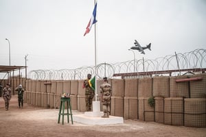 Un avion français de l’opération Barkhane survole le camp lors de la cérémonie des drapeaux, où le français sera remplacé par le malien, lors de la cérémonie de rétrocession du camp français à l’armée malienne, à Tombouctou, le 14 décembre 2021. © Florent Vergnes pour JA