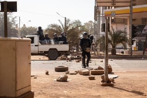 Des membres des forces de sécurité retirent des barricades installées par des manifestants, le 22 janvier 2022, à Ouagadougou. © AFP/OLYMPIA DE MAISMONT