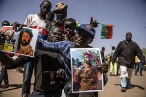 Un manifestant à Ouagadougou, mardi 25 janvier 2022, brandit des portrait du lieutenant-colonel burkinabè Damiba et du colonel malien Goïta. © Sophie Garcia/AP/SIPA