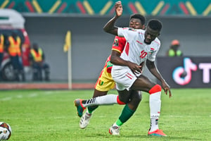 Pius Utomi EKPEI / AFP © Le milieu de terrain gambien Musa Barrow (à droite) se bat pour la possession du ballon face au défenseur guinéen Saidou Sow (à gauche) en 8e de finale de la CAN 2022.