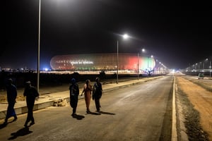 Des piétons au pied du nouveau stade olympique Abdoulaye Wade à Diamniadio, le 22 janvier. © JOHN WESSELS/AFP