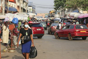 Une femme portant un masque pour se protéger du Covid-19 dans une rue de Lomé (Togo), le 29 décembre 2021. © Alphonse Logo/ Anadolu Agency via AFP.