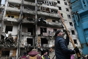 Des Ukrainiens nettoient après qu’un missile russe a endommagé un bâtiment lors de l’invasion de l’Ukraine par la Russie, dans le quartier de Kharkivskiy, à  Kiev, le 25 février 2022. © Justin Yau/Sipa USA/SIPA.