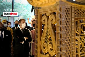 Le président français, Emmanuel Macron, devant les œuvres restituées au Bénin, lors d’une exposition le 27 octobre 2021 à Paris. © Michel Euler/POOL/AFP