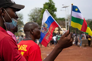Manifestation de soutien à la Russie dans sa guerre contre l’Ukraine, à Bangui, le 5 mars 2022. Russian and Central African Republic flags are waived by demonstrators gathered in Bangui on March 5, 2022 during a rally in support of Russia. – A hundred people participated Saturday in Bangui, the capital of the Central African Republic, in a demonstration in support of Russia in its offensive against Ukraine. The demonstrators gathered at the foot of a statue, inaugurated at the end of 2021 by President Faustin Archange TouadÈra, representing Russian fighters who protect a woman and her children. Many of them waved Russian and Central African flags in the heart of the capital, near the university. 
© Carol VALADE / AFP