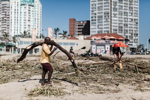 Des volontaires nettoient les dégâts provoqués par les inondations, le 15 avril 2022 à Durban, en Afrique du Sud. © RAJESH JANTILAL / AFP