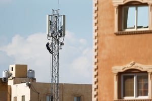 En Afrique, encore 19 % de la population n’est pas couvert par la téléphonie mobile. Ici, un technicien réparant une antenne de communication mobile au sommet d’une tour Vodafone dans la banlieue cairote de Maadi, en Égypte, en novembre 2020. © Amr Abdallah Dalsh/Reuters
