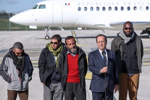 François Hollande et les ex-otages Marc Feret, Pierre Legrand, Daniel Larribe et Thierry Dol à l’aéroport de Villacoublay, près de Paris, le 30 octobre 2013 © KENZO TRIBOUILLARD / AFP