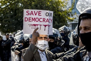 Des centaines de Tunisiens rassemblés sur la place du Bardo, près du Parlement, pour protester contre la prise de pouvoir du président Kaïs Saïed, à Tunis, en Tunisie, le 14 novembre 2021. © Nacer Talel/Anadolu Agency via AFP