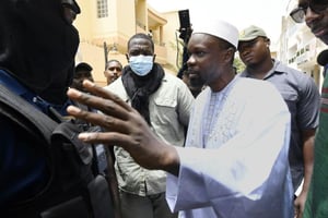 Le leader de l’opposition Ousmane Sonko parle avec des policiers devant chez lui, le 17 juin 2022 à Dakar. © afp.com – Seyllou